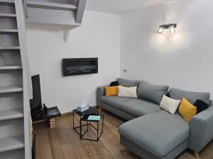a living room with a couch and a tv at La maison des galeries classé 4 étoiles in Fécamp