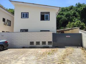 una casa blanca con una puerta delante de ella en Apto 2 quartos próx. Floripa Shopping, en Florianópolis