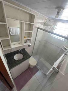 y baño con ducha de cristal y aseo. en Apto 2 quartos próx. Floripa Shopping, en Florianópolis