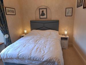 Lloyds Penthouse في تافيستوك: غرفة نوم بسرير ابيض كبير مع مواقف ليلتين