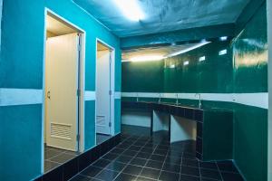 a bathroom with blue walls and a sink and a mirror at Happiness Community Wake & Bake Hostel - Rooftop Bar & Bistro in Pattaya