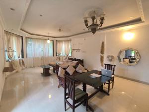 uma sala de estar com uma mesa e uma sala de jantar em J-House, spacious apartments with balconies, Thalassa 1min away em Siolim