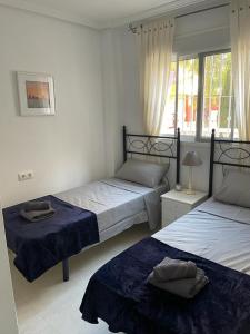 1 Schlafzimmer mit 2 Betten und einem Fenster in der Unterkunft Ground floor apartment with 3 pools in Murcia