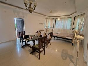 a living room with a table and a couch at J-House, spacious apartments with balconies, Thalassa 1min away in Siolim