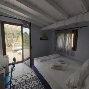 a bedroom with a bed and a large window at Beach House Onar in Diaporos