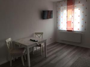 comedor con mesa, sillas y ventana en Apartmentvermietung Ingrid Bolkart - Kirchblick 1, en Illertissen