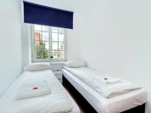 two beds in a room with a window at Happiness Holidays - Old Town 10 in Gdańsk