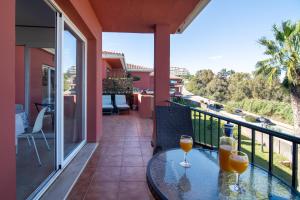 twee glazen sinaasappelsap op een tafel op een balkon bij Spacious condo with Sea View, Walking distance to the Beach, Parking, Pool, WiFi in Manilva