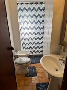 a bathroom with two toilets and a sink and a shower at Nic holiday house in Santa Marinella