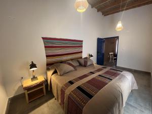1 dormitorio con 1 cama grande y mesa auxiliar en Ckoi Atacama Lodge, en San Pedro de Atacama