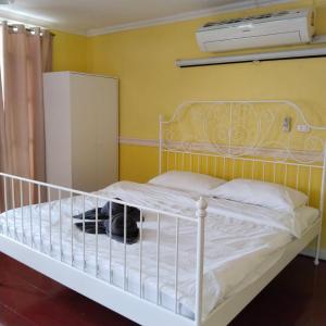 a bedroom with a white bed and a refrigerator at AranHostel&Cafe in Ban Bang Khen (1)
