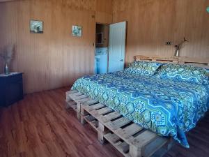 1 dormitorio con 1 cama con edredón azul en Petrohue hospedaje Dónde la Nena, en Petrohué