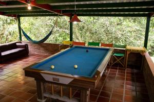 einen Billardtisch in einem Zimmer mit Hängematte in der Unterkunft Ecohotel Monteverde in La Vega