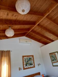 um quarto com tecto de madeira e 2 luzes em צימר דביר em Kefar H̱ananya