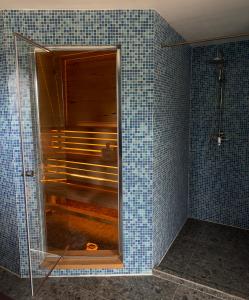 y baño con ducha y azulejos azules. en Ubytovanie u Slovana Chata, 