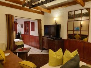 a living room with a couch and a flat screen tv at Ferienwohnung Villa del Viola Leonardo Apartment in Heinsberg