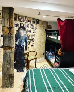 - une chambre avec un lit et un mur avec des photos dans l'établissement Les sorciers, la Diligence St Jean de Losne, à Saint-Jean-de-Losne