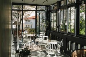 a patio with white chairs and tables and windows at Hotel Edouard VII in Biarritz