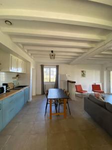 cocina y sala de estar con mesa y sofá en Gîte de la Madeleine 3*, proche de la Loire, en Gennes