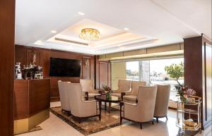 Laten Suites Prince Sultan في جدة: غرفة بطاولة وكراسي وتلفزيون