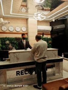 a man is standing at a reception desk at Hotel Lake View Airport zone in Hyderabad