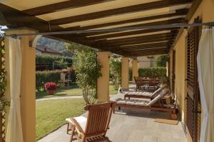 a patio with chairs and a wooden pergola at CàMia Lovely house ValDiVara 5Terre hiking in Sesta Godano
