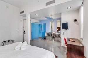 a bedroom with a white bed and a kitchen at Keating in San Diego