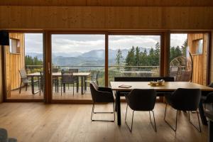 Una habitación con una mesa y sillas y un balcón. en Holzhaus "Zum Schwarz'n", en Aurach am Hongar