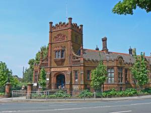 an old brick building with a clock tower on a street at Central Two Bed Flat Kings Lynn in Kings Lynn