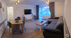 a living room with a couch and a table at Къща за гости Сънрайс Чепеларе in Chepelare
