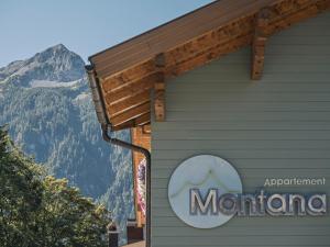 a sign on the side of a building with a mountain at Apart Garni Montana in Pertisau