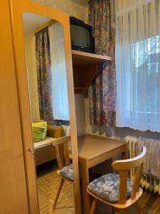 Mały pokój z biurkiem, stołem i krzesłami w obiekcie Einzel Zi Nr 2 w mieście Freiensteinau