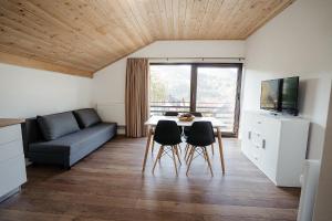 ein Wohnzimmer mit einem Tisch, Stühlen und einem Sofa in der Unterkunft Green Garden in Băile Borşa