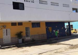 a man standing in front of a blue and yellow building at La Quinta INN in Santa Marta