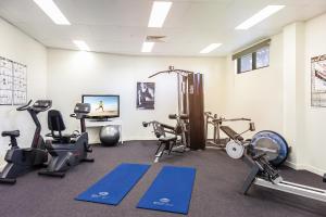 a gym with several exercise equipment in a room at Pandanus Mooloolaba in Mooloolaba