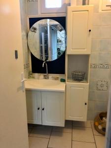 ein Bad mit einem Waschbecken und einem Spiegel in der Unterkunft Comme à la maison in Marsan