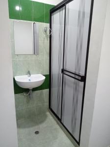 a bathroom with a sink and a glass shower stall at La Quinta INN in Santa Marta