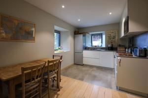 a kitchen with a wooden table and a dining room at 300-year-old Farmhouse Chalet in Servoz