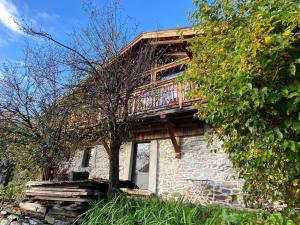 a stone house with a deck on top of it at 300-year-old Farmhouse Chalet in Servoz