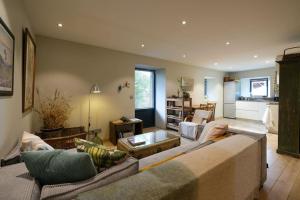 a living room with two couches and a kitchen at 300-year-old Farmhouse Chalet in Servoz