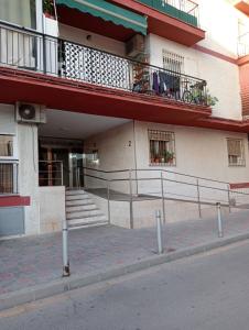 ein Gebäude mit Balkonen und Treppen auf einer Straße in der Unterkunft Playa Beach Malaga 3habts dobles, cocina familiar, apartamento completo in La Cala del Moral