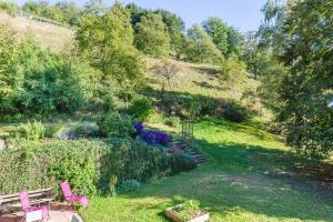 un jardín con un banco y flores en una colina en Coté tilleul, en Bourbach-le-Bas