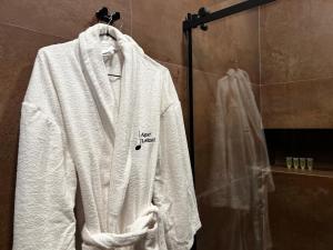 ein weißer Bademantel hängt an einem Kleiderständer im Bad in der Unterkunft Apart leitmotif in Tbilisi City