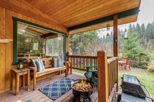 una veranda riparata con griglia e panca di Rivers Edge by NW Comfy Cabins a Leavenworth