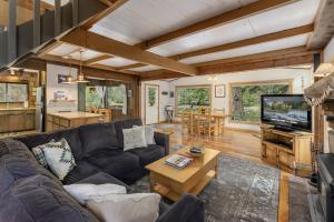 un soggiorno con un divano e una TV di Rivers Edge by NW Comfy Cabins a Leavenworth