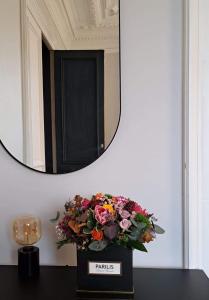 a bouquet of flowers on a table in front of a mirror at Appartement Maison de Maître in Seraing