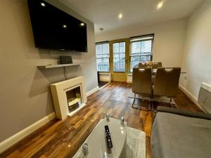 a living room with a fireplace and a tv at 2 Bedroom Flat Ground Floor Town Centre Colchester in Colchester