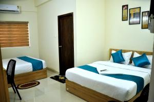 um quarto com 2 camas com lençóis azuis e brancos em MARHABA PALACE em Calecute