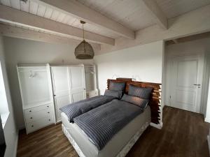 een slaapkamer met een bed met 2 kussens erop bij Muggelhuus das Ferienhaus im Alten Land / Pflaumenbaum in Twielenfleth