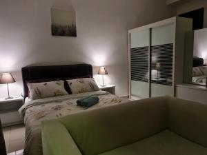 a bedroom with a bed with a couch and a mirror at The Urban Getaway - 118 Tower View in Cyberjaya